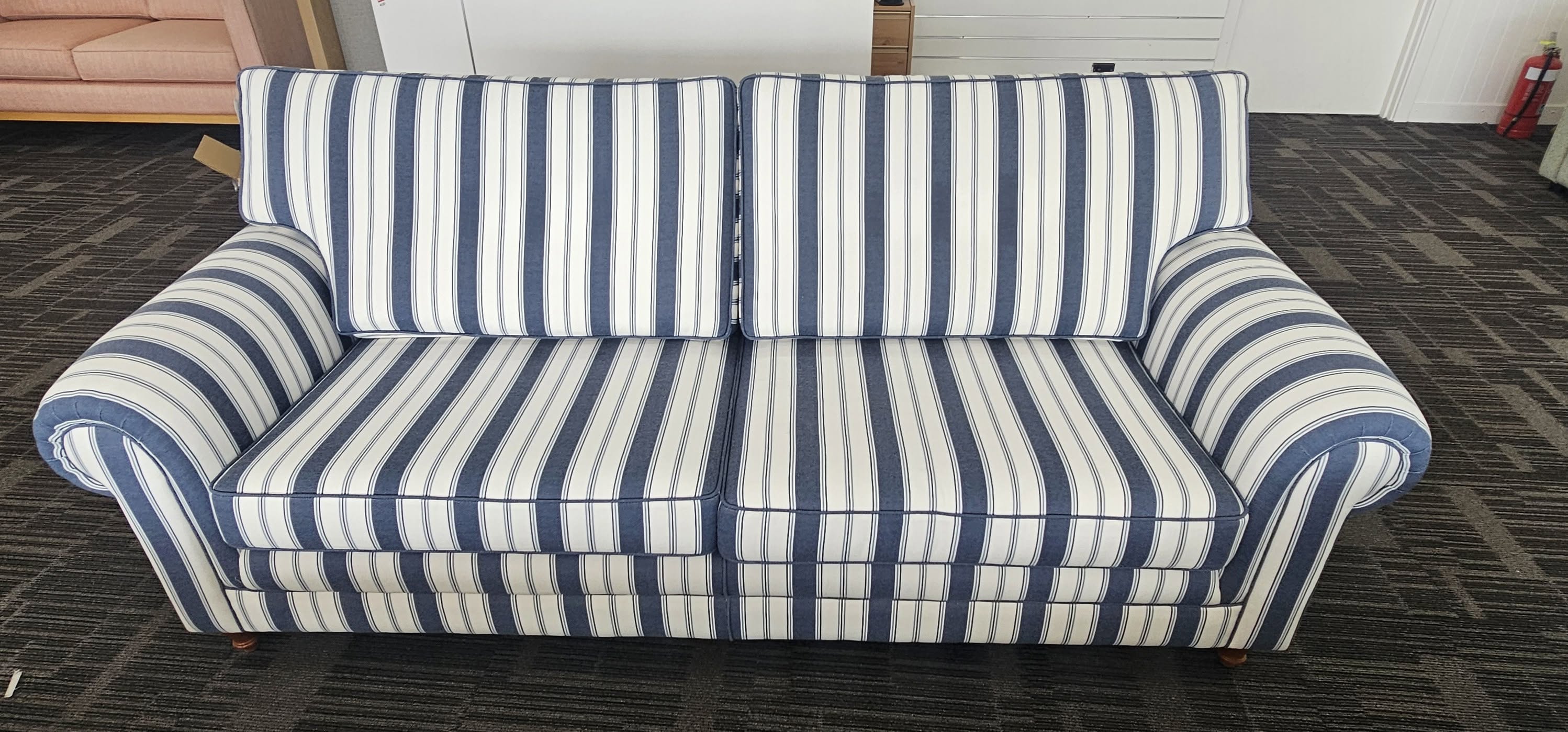 Navy and white striped sofa with rolled arms and turned timber feet