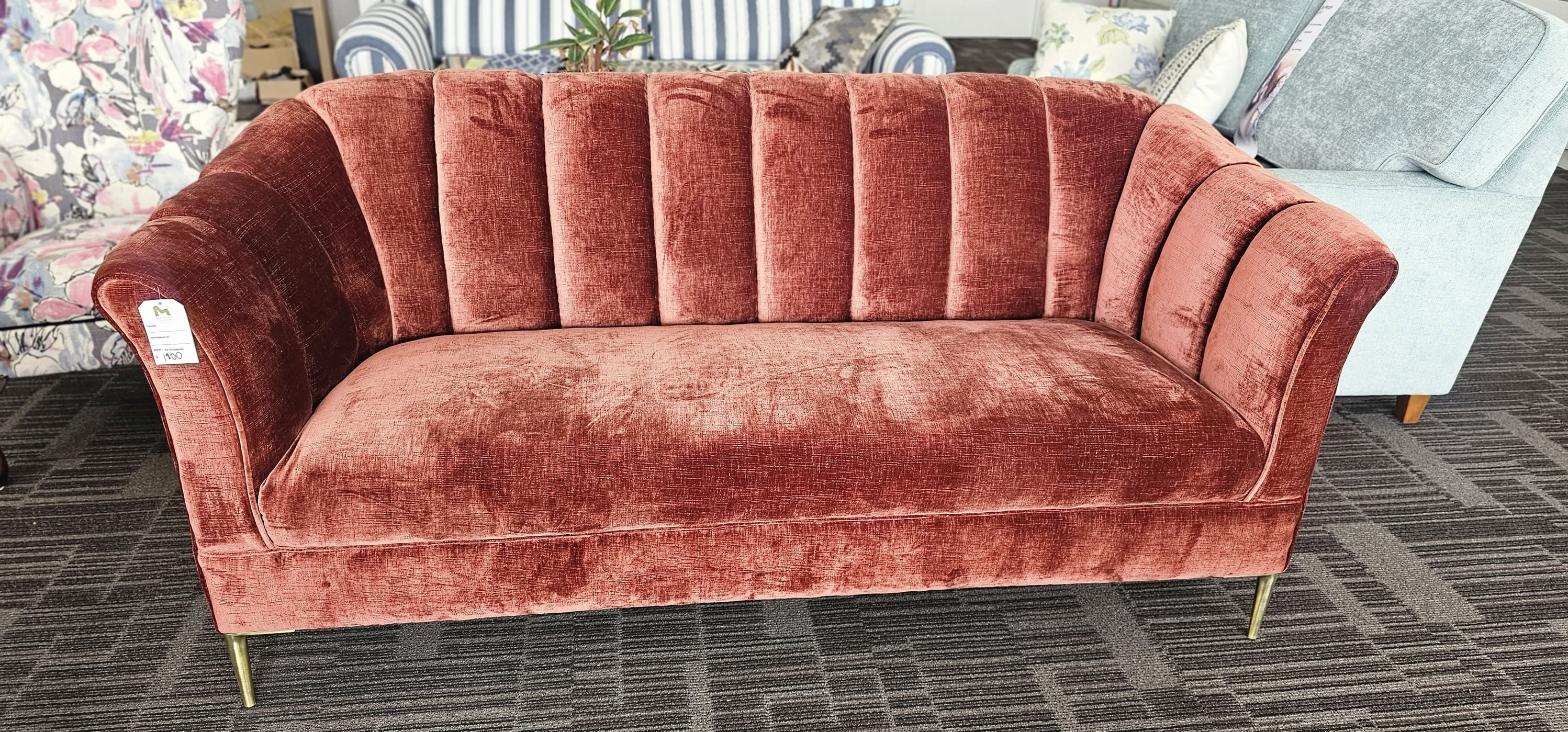Rust velvet sofa with channelled back and brass legs