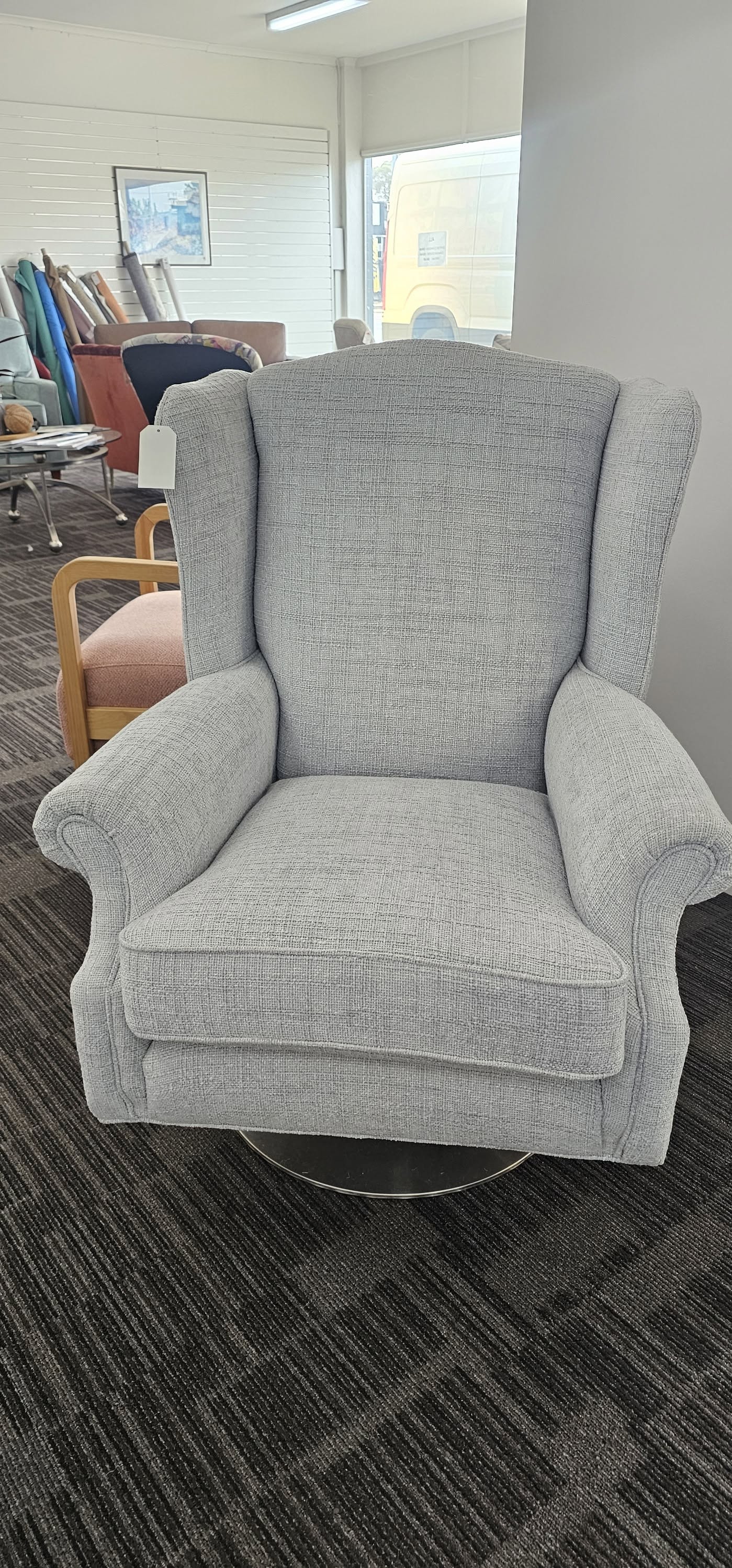 Grey textured wingback armchair on a swivel base